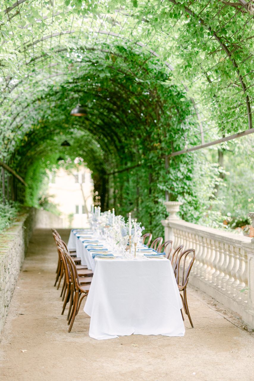 Savoia Castle — long laid table under a green pergola tunnel in the garden